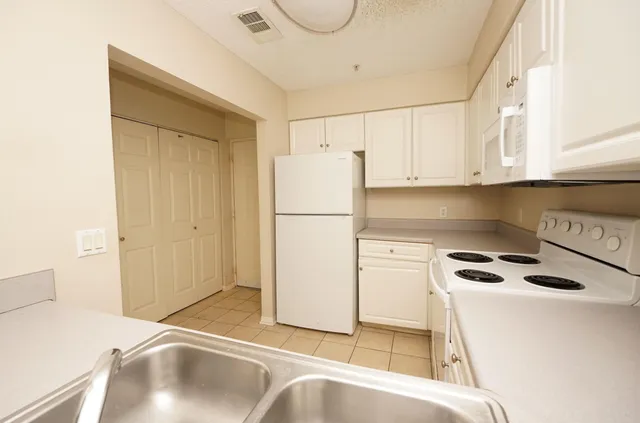 a kitchen with a refrigerator a stove top oven and a cabinets