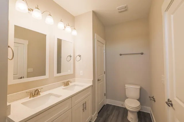 a bathroom with a granite countertop sink toilet a large mirror a shower and a bathtub