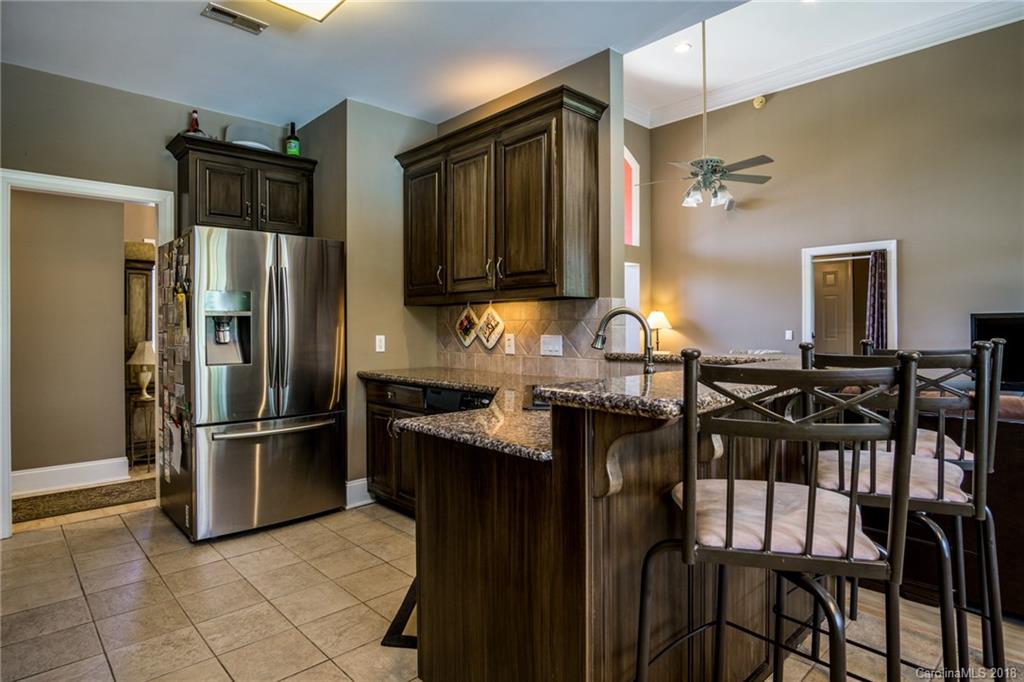 3526 Sincerity Road, Unit 13 Monroe, NC 28110 - Photo 7 of 20 a kitchen with granite countertop a refrigerator and a stove top oven