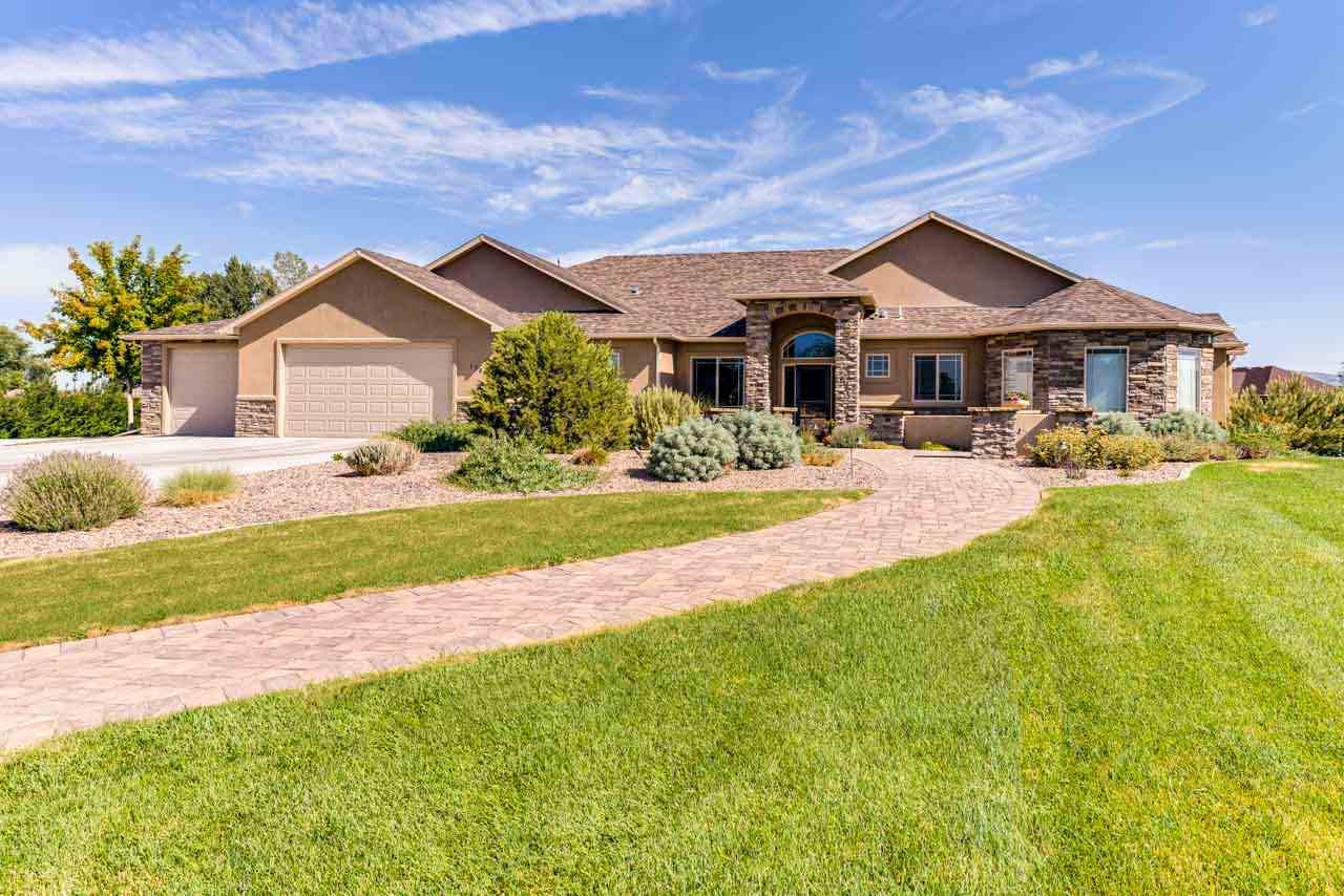 2530 Riata Ranch Court Grand Junction, CO 81505 - Photo 1 of 41 a front view of a house with yard and green space