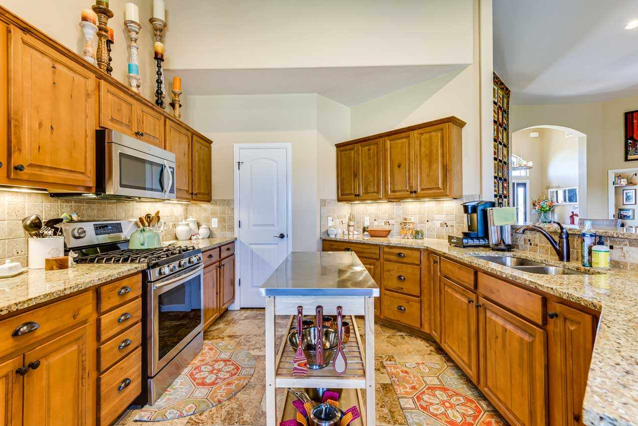 2530 Riata Ranch Court Grand Junction, CO 81505 - Photo 13 of 41 a kitchen with stainless steel appliances granite countertop a stove top oven a sink dishwasher and cabinets with wooden floor