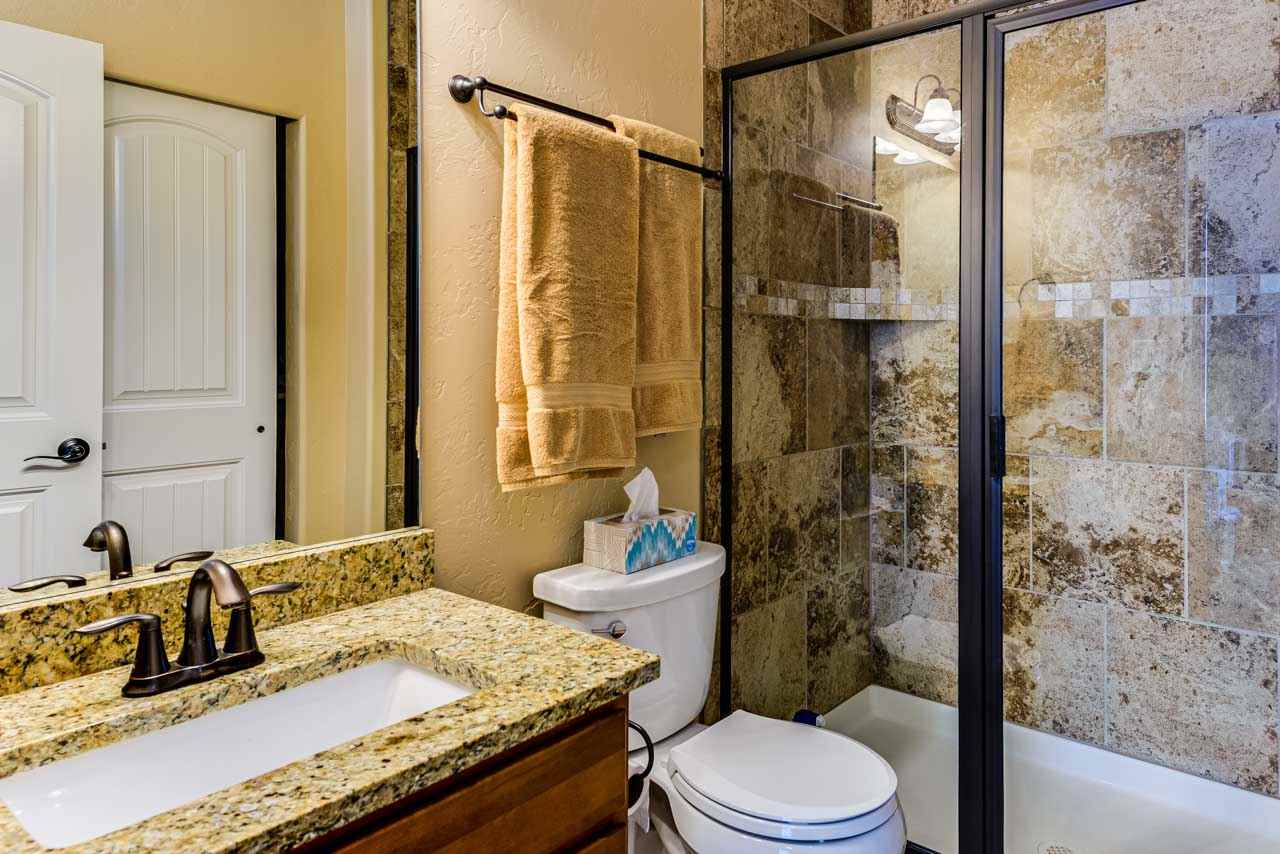 2530 Riata Ranch Court Grand Junction, CO 81505 - Photo 23 of 41 a bathroom with a granite countertop sink toilet a mirror and shower
