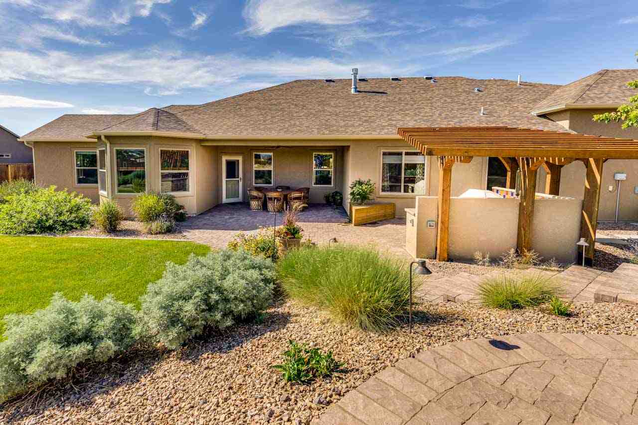2530 Riata Ranch Court Grand Junction, CO 81505 - Photo 33 of 41 a view of a house with backyard sitting area and garden