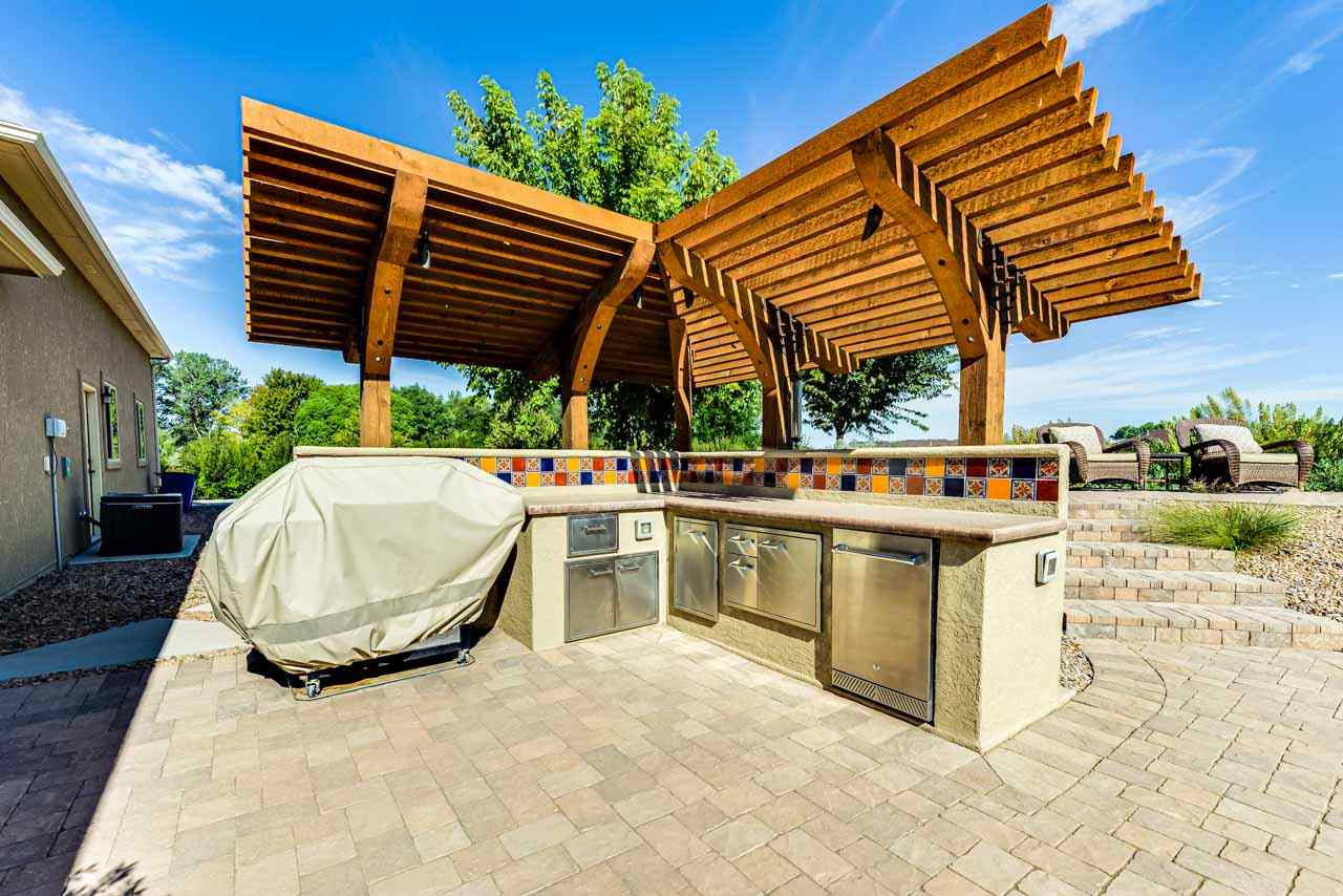 2530 Riata Ranch Court Grand Junction, CO 81505 - Photo 35 of 41 a view of a patio with table and chairs under an umbrella with a small yard
