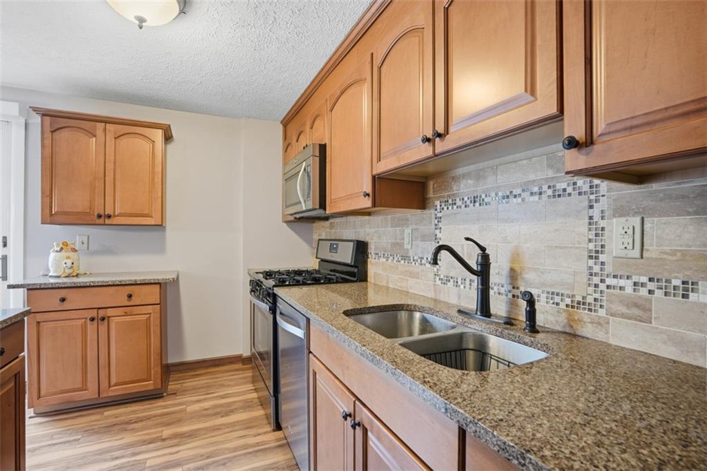 106 Squirrel Hollow Road Gibsonia, PA 15044 - Photo 11 of 46 a kitchen with granite countertop a sink a stove and cabinets