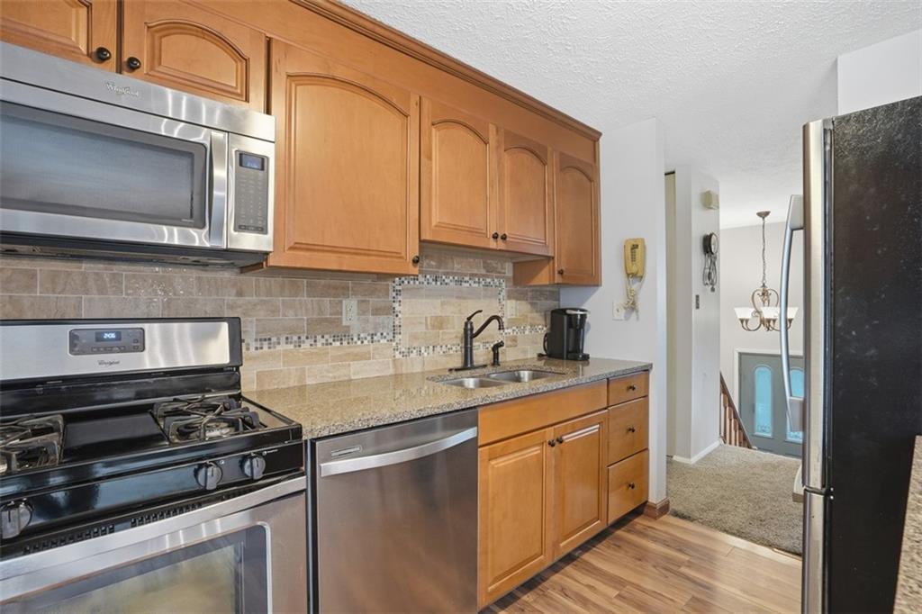 106 Squirrel Hollow Road Gibsonia, PA 15044 - Photo 13 of 46 a kitchen with stainless steel appliances granite countertop a stove a refrigerator and a microwave