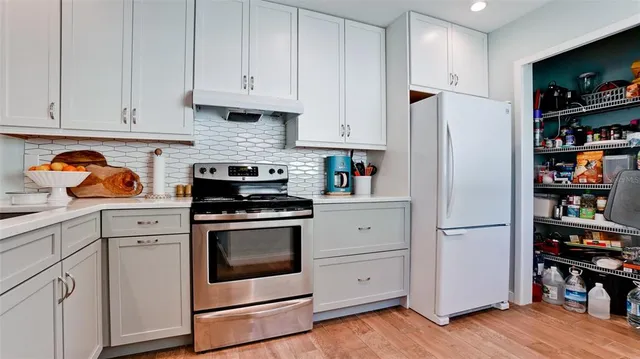 a kitchen with stainless steel appliances granite countertop a refrigerator and a stove
