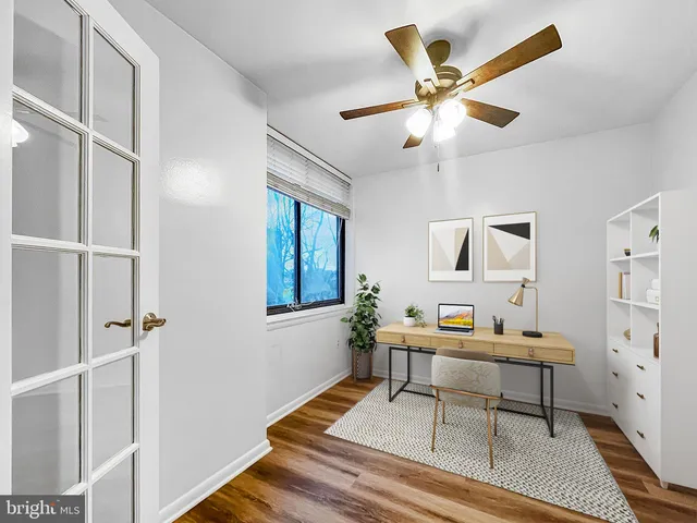 a workspace with wooden floor and a chandelier fan