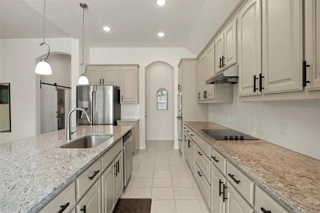 a kitchen with stainless steel appliances granite countertop a sink and stove