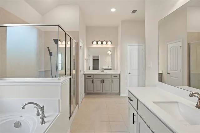 a bathroom with a shower sink vanity and mirror