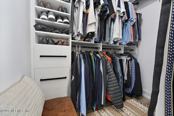 a view of walk in closet with clothes and shoes