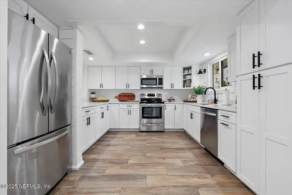 a kitchen with stainless steel appliances a refrigerator sink and cabinets