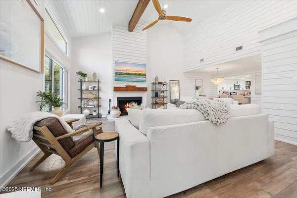 a living room with furniture a fireplace and a flat screen tv
