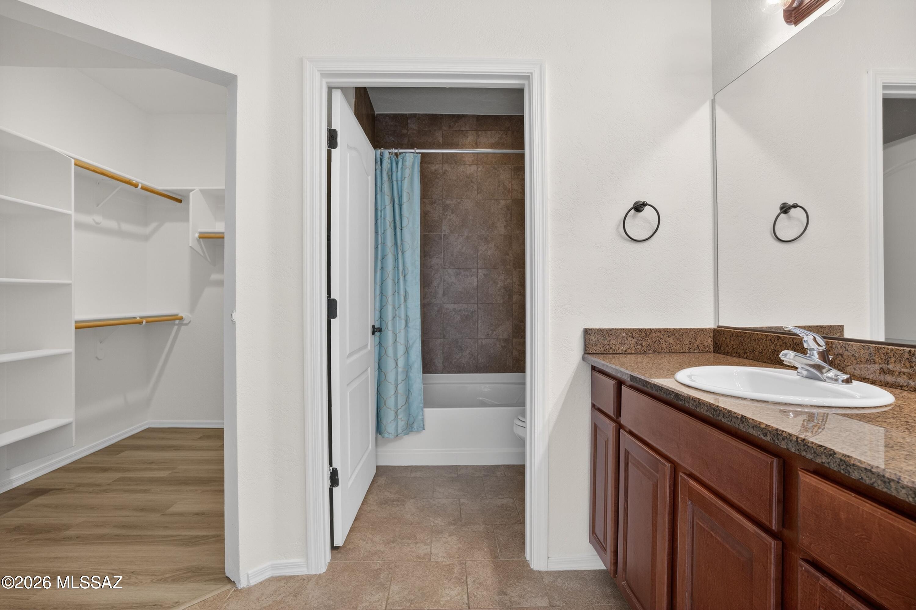 2550 East River Road, Unit 4204 Tucson, AZ 85718 - Photo 19 of 36 a bathroom with a granite countertop sink a mirror and a shower