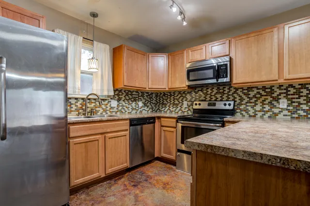 a kitchen with stainless steel appliances granite countertop a sink stove and microwave