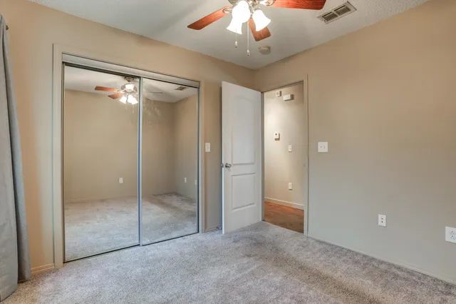 a bathroom with a granite countertop toilet sink and mirror