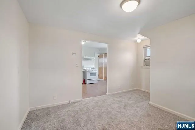an empty room with an entryway and wooden floor