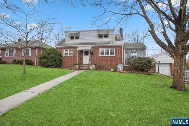 a view of a house with a big yard and large trees