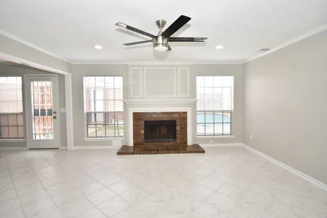 a view of an empty room with a fireplace and a window