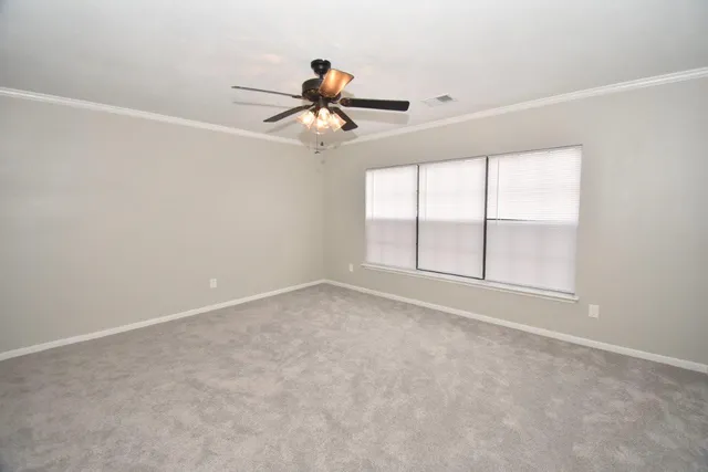 an empty room with windows and fan