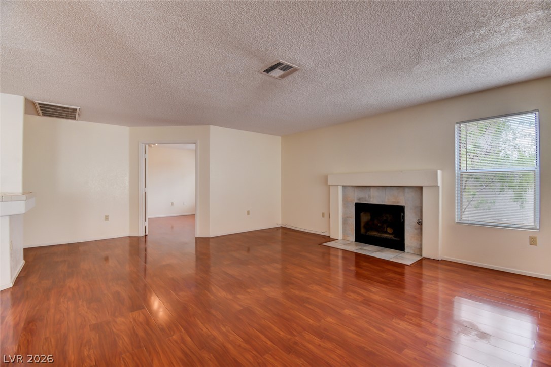 5 Tarryall Terrace Henderson, NV 89074 - Photo 19 of 44 Refined wood flooring complements a cozy fireplace, creating an inviting atmosphere.