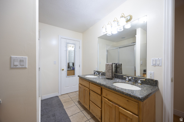 1981 South Main Street Lewiston, UT 84320 - Photo 4 of 47 Full bathroom featuring double vanity, light tile patterned floors, and a stall shower