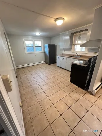a kitchen with stainless steel appliances kitchen island granite countertop white cabinets and window