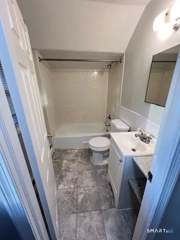 a bathroom with a sink a toilet a mirror and shower