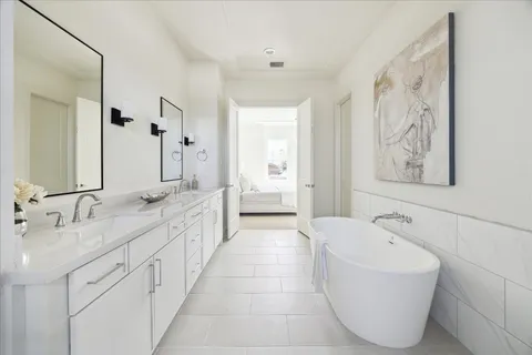 a spacious bathroom with a tub sink and mirror