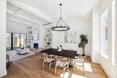 a dining room with furniture a chandelier and wooden floor