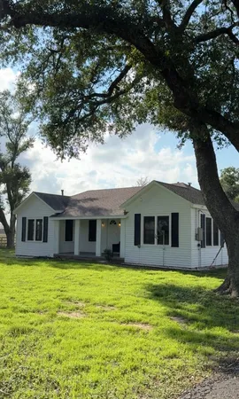 a house that has a big yard with large trees