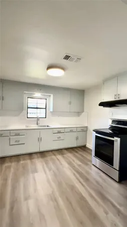 a view of a kitchen with wooden floor and electronic appliances