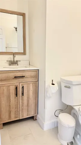 a bathroom with a granite countertop toilet sink and mirror