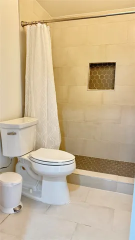 a bathroom with a toilet and a shower curtain