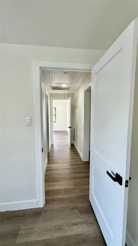 a view of a hallway with wooden floor
