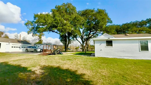 a view of a yard with a house and a large tree