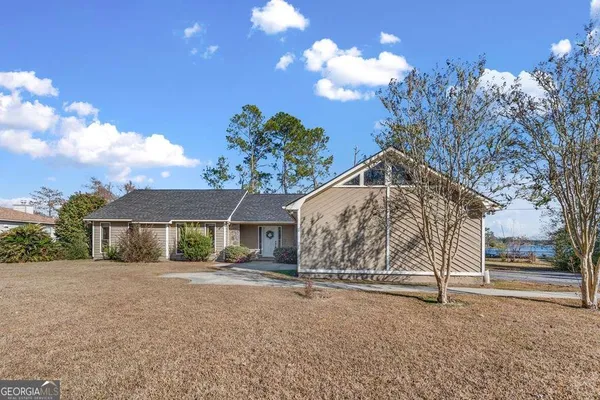 a view of house with a yard and potted plants