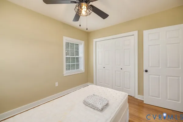 a bedroom with a bed and a chandelier fan