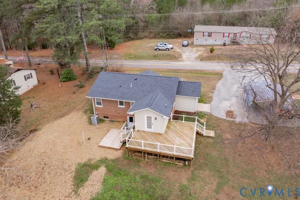 an aerial view of a house with swimming pool and large trees