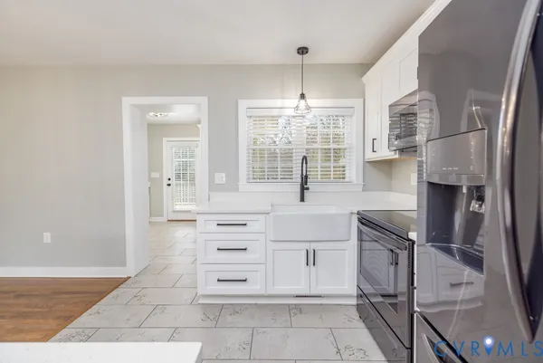 a kitchen with granite countertop a sink cabinets and stainless steel appliances