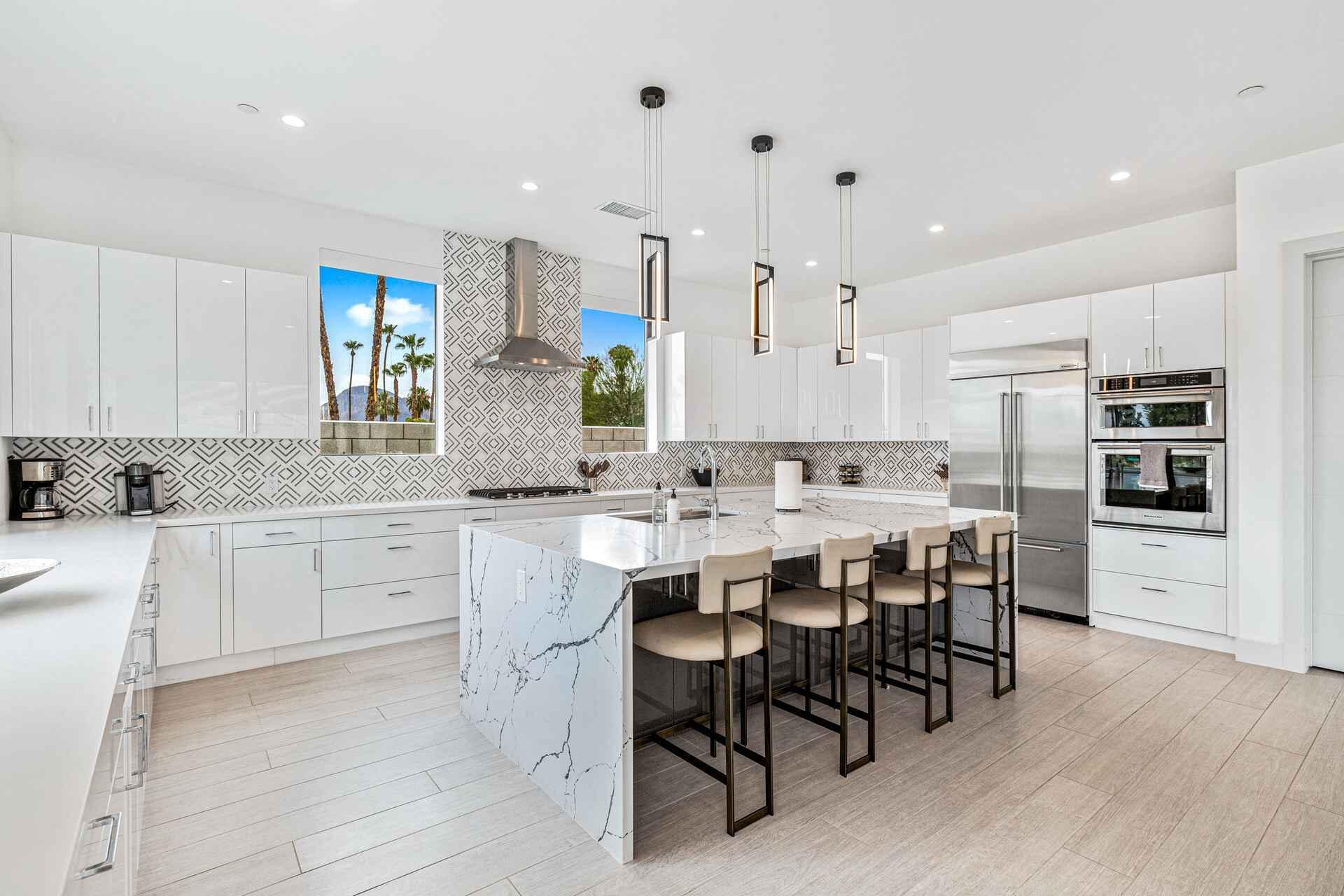 72985 Somera Road Palm Desert, CA 92260 - Photo 15 of 33 a kitchen with kitchen island granite countertop a table chairs sink and cabinets