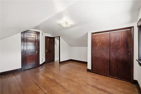 an empty room with wooden floor door and windows