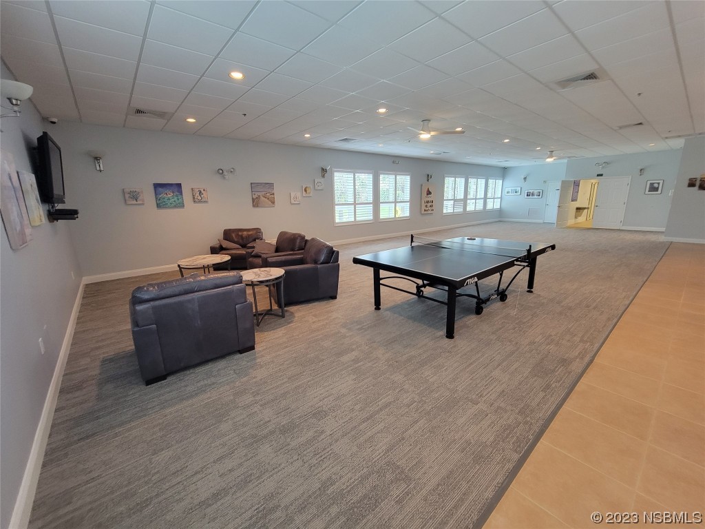 4623 Rivers Edge Village Lane, Unit 6204 Ponce Inlet, FL 32127 - Photo 29 of 62 a living room with furniture a flat screen tv and a wooden floor
