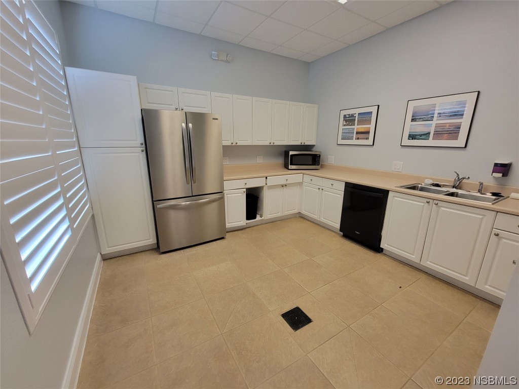 4623 Rivers Edge Village Lane, Unit 6204 Ponce Inlet, FL 32127 - Photo 32 of 62 a kitchen with a sink a refrigerator and cabinets