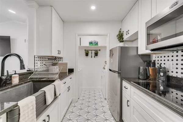 a kitchen with stainless steel appliances a refrigerator sink and cabinets