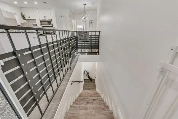 a view of a hallway with wooden floor and staircase