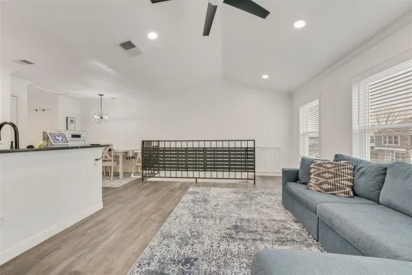 a living room with stainless steel appliances furniture a rug and a large window