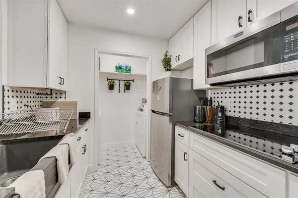 a kitchen with granite countertop a refrigerator and a stove