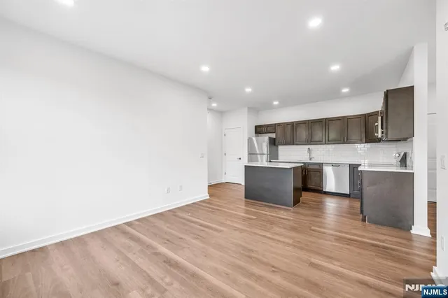 a large kitchen with stainless steel appliances kitchen island a large counter top and a stove top oven