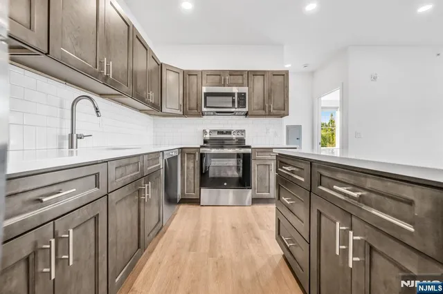 a kitchen with stainless steel appliances granite countertop a sink stove and cabinets